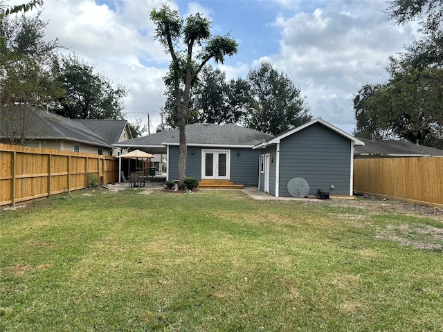 rear view of property with a yard, a patio area, and french doors