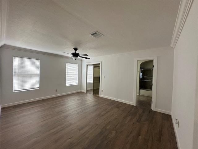 spare room featuring a textured ceiling, ceiling fan, ornamental molding, and dark wood-type flooring