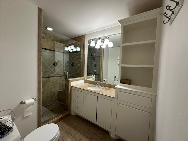 bathroom with tile patterned flooring, vanity, a shower with door, and toilet