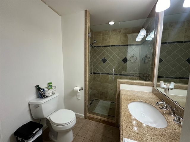 bathroom with tile patterned floors, vanity, a shower with shower door, and toilet