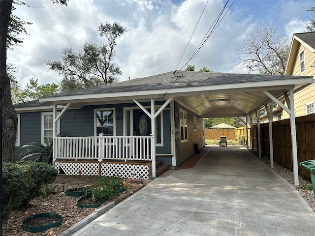 6811 Roswell St, Houston, TX 77022 - view of front of property with concrete driveway, covered porch, a carport, and a shingled roof