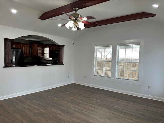 empty room featuring vaulted ceiling with beams, ceiling fan, and dark hardwood / wood-style flooring