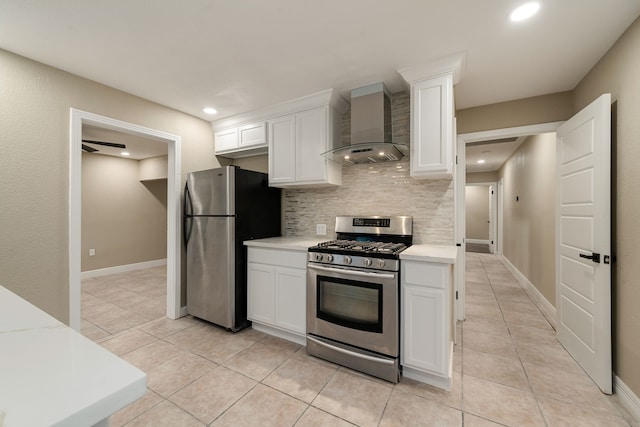 kitchen featuring appliances with stainless steel finishes, backsplash, wall chimney exhaust hood, light tile patterned floors, and white cabinets