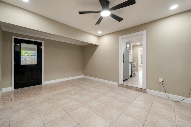 tiled empty room with ceiling fan and crown molding