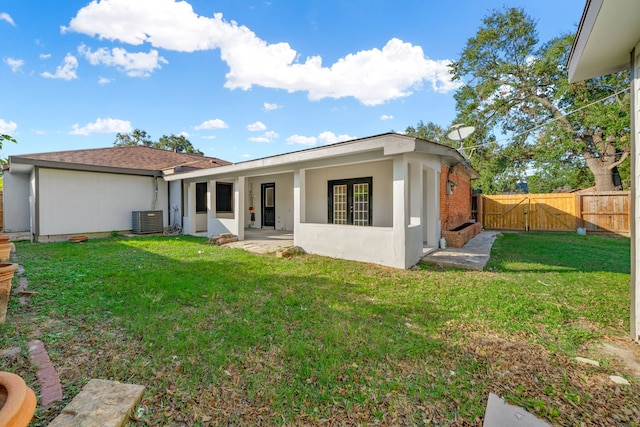 back of property featuring a lawn, a patio area, and central AC unit