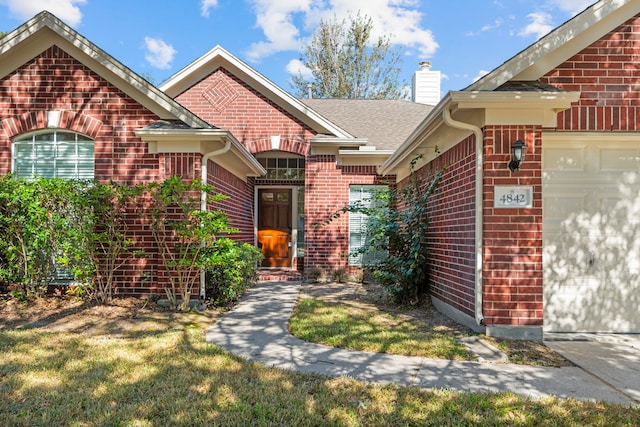 entrance to property with a yard and a garage