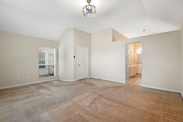 unfurnished room with light carpet and high vaulted ceiling