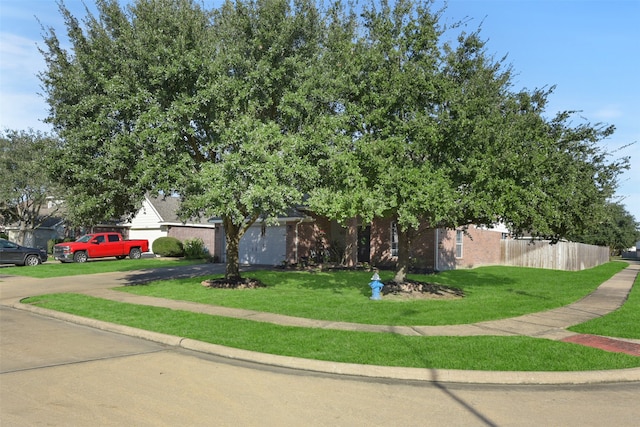 view of property hidden behind natural elements featuring a front yard