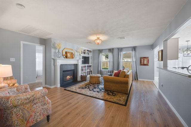 living room with a tiled fireplace, a healthy amount of sunlight, and wood-type flooring