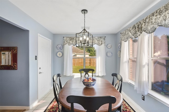 tiled dining space featuring a chandelier and a wealth of natural light