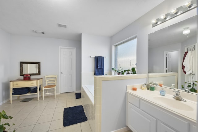 bathroom with tile patterned flooring, a bathtub, and vanity