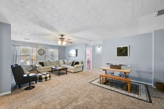 living room featuring ceiling fan, carpet, and a textured ceiling