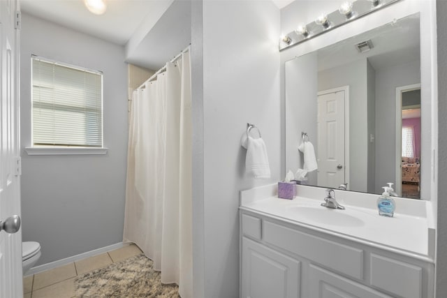 bathroom with toilet, vanity, and tile patterned floors