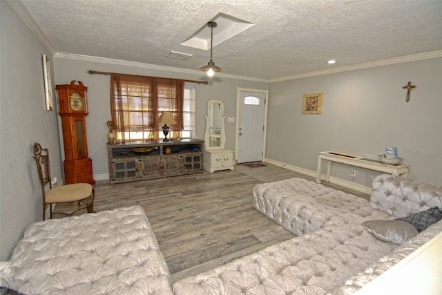 living room with a skylight, light hardwood / wood-style floors, a textured ceiling, and ornamental molding