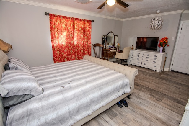 bedroom featuring ceiling fan, hardwood / wood-style floors, crown molding, and a textured ceiling