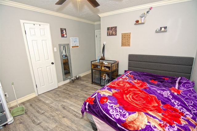 bedroom with ceiling fan, hardwood / wood-style floors, crown molding, and a textured ceiling