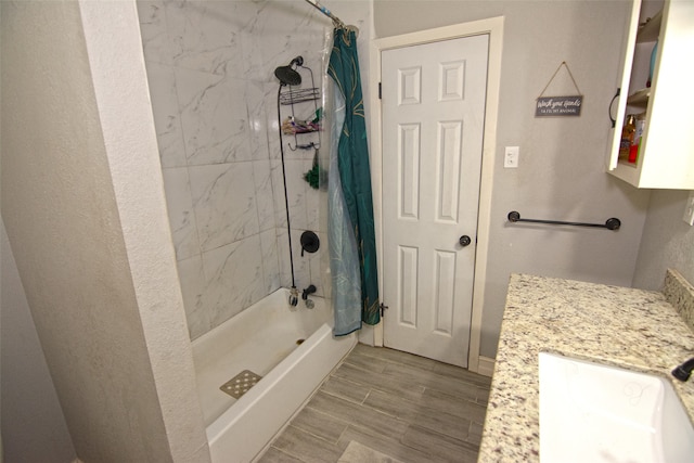 bathroom with hardwood / wood-style floors, vanity, and shower / bathtub combination with curtain