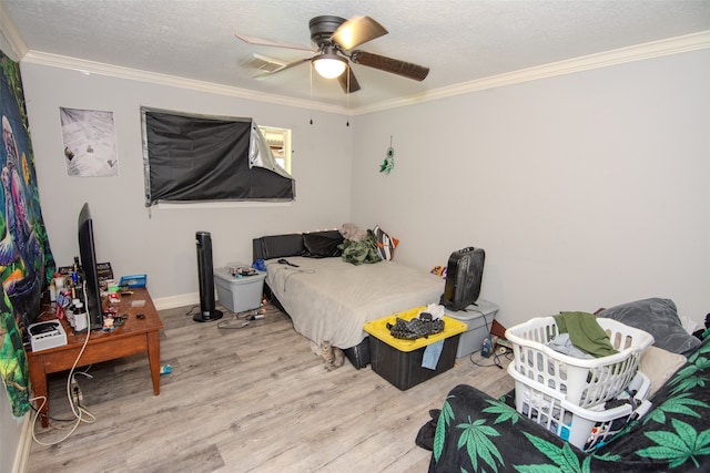 bedroom with ceiling fan, light hardwood / wood-style floors, a textured ceiling, and ornamental molding