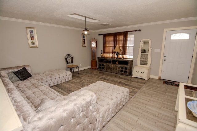 living room with hardwood / wood-style floors, a textured ceiling, and crown molding