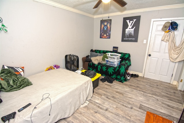 bedroom featuring ceiling fan, crown molding, wood-type flooring, and a textured ceiling