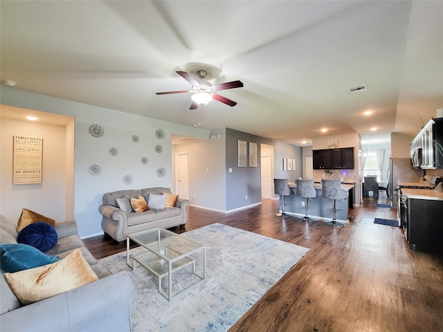 living room with dark hardwood / wood-style flooring and ceiling fan