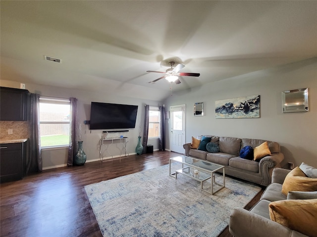 living room featuring ceiling fan, lofted ceiling, and dark wood-type flooring