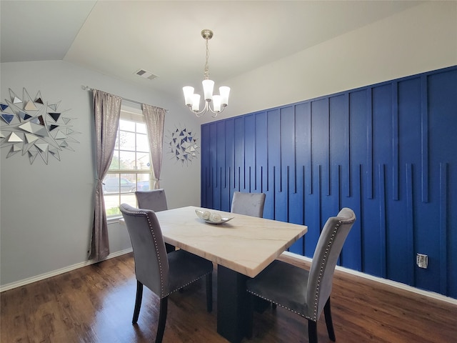 dining space featuring dark hardwood / wood-style floors, lofted ceiling, and a notable chandelier