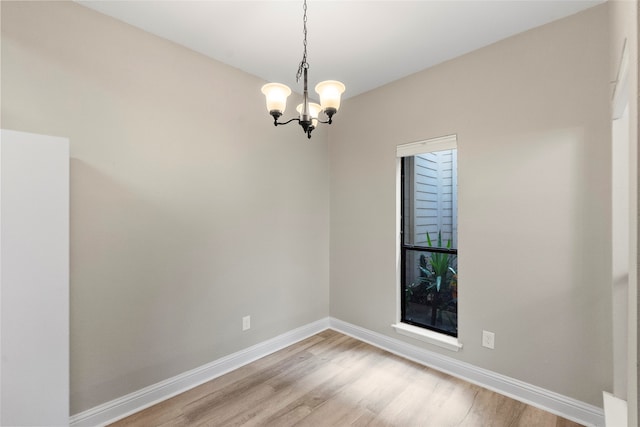 unfurnished room with light hardwood / wood-style flooring and a chandelier