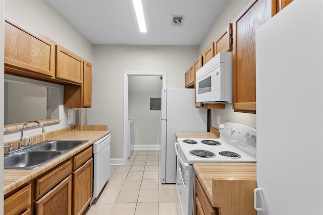 kitchen featuring washer and clothes dryer, white appliances, sink, and light tile patterned floors