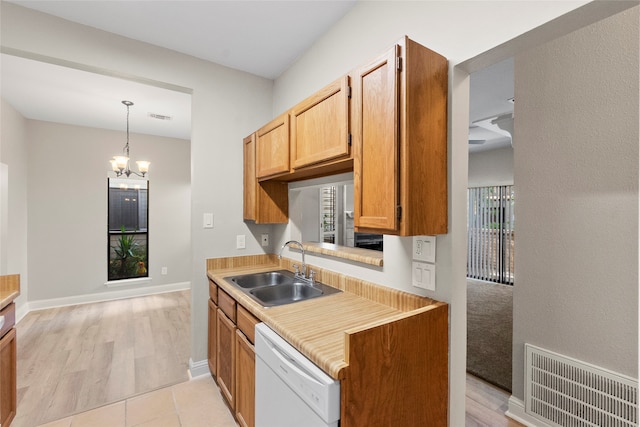 kitchen featuring sink, hanging light fixtures, an inviting chandelier, white dishwasher, and light hardwood / wood-style floors