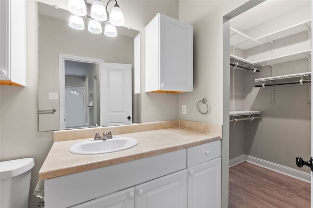 bathroom with hardwood / wood-style floors, vanity, and toilet