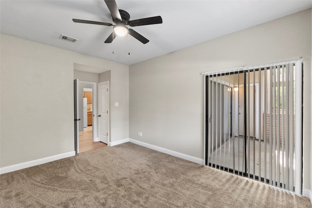 carpeted spare room with ceiling fan