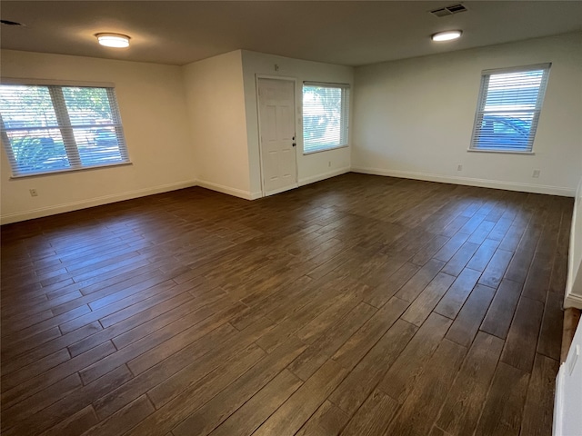 spare room with dark hardwood / wood-style flooring and a wealth of natural light