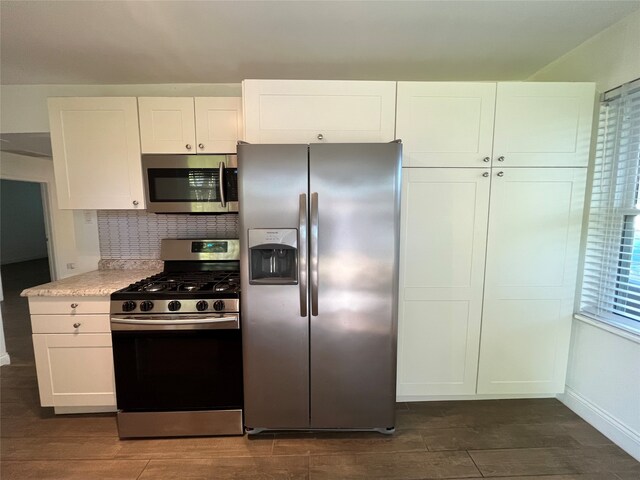 kitchen with backsplash, white cabinetry, and stainless steel appliances