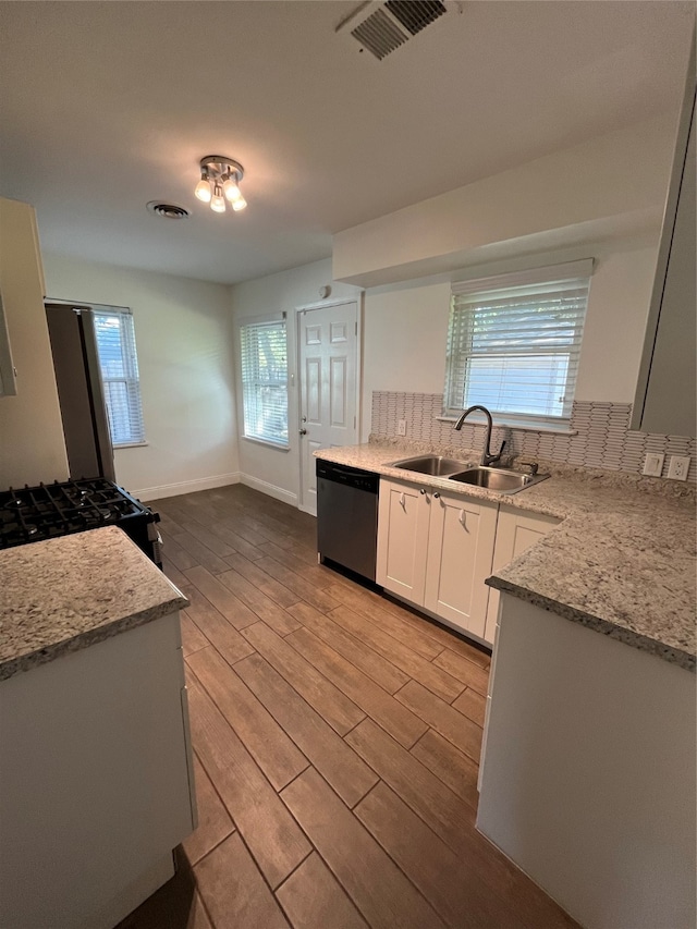 kitchen featuring a wealth of natural light, sink, dishwasher, light hardwood / wood-style floors, and white cabinetry