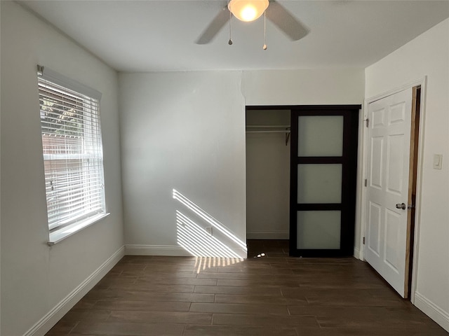 unfurnished bedroom with ceiling fan, dark hardwood / wood-style floors, and a closet