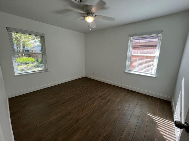 spare room with dark hardwood / wood-style flooring, ceiling fan, and a healthy amount of sunlight