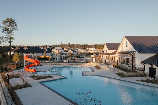 view of pool with a water slide and a patio