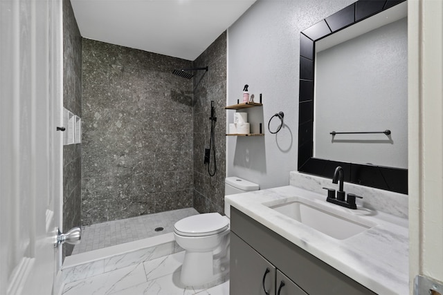 bathroom featuring vanity, toilet, and a tile shower