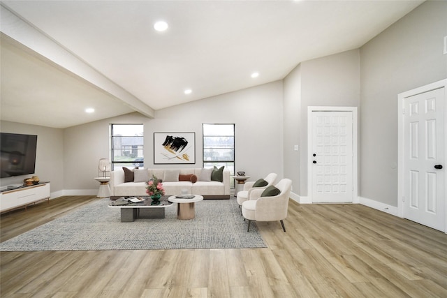 living room featuring lofted ceiling with beams and light wood-type flooring