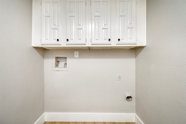 laundry room with hookup for an electric dryer, washer hookup, light hardwood / wood-style floors, and cabinets