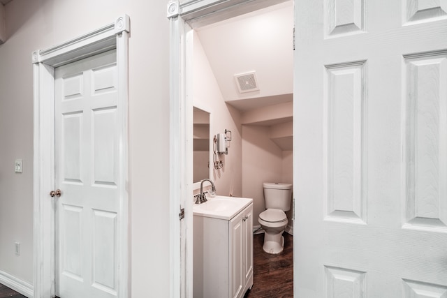 bathroom featuring vanity, wood-type flooring, and toilet