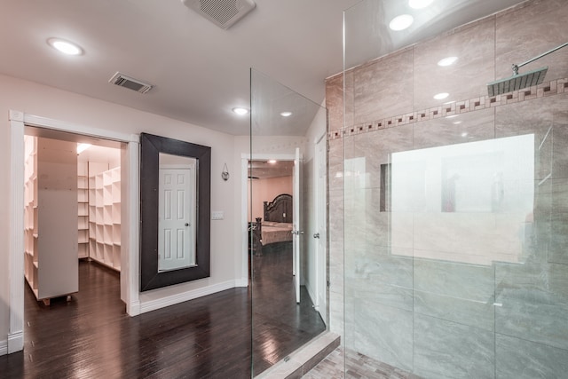 bathroom with hardwood / wood-style flooring and a tile shower