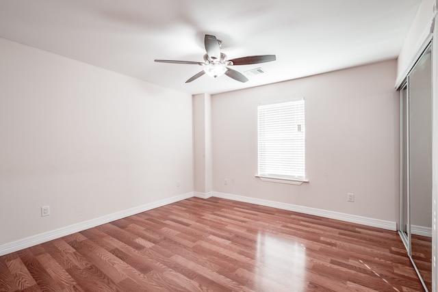 unfurnished bedroom with wood-type flooring, a closet, and ceiling fan