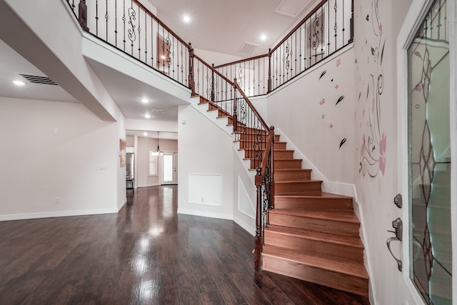 foyer entrance featuring a high ceiling and dark hardwood / wood-style flooring