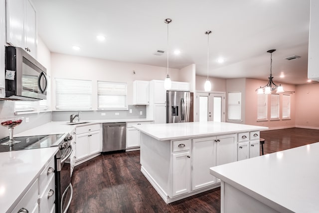 kitchen with stainless steel appliances, a center island, and white cabinets