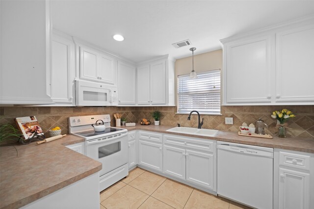 kitchen featuring sink, white cabinets, hanging light fixtures, and white appliances