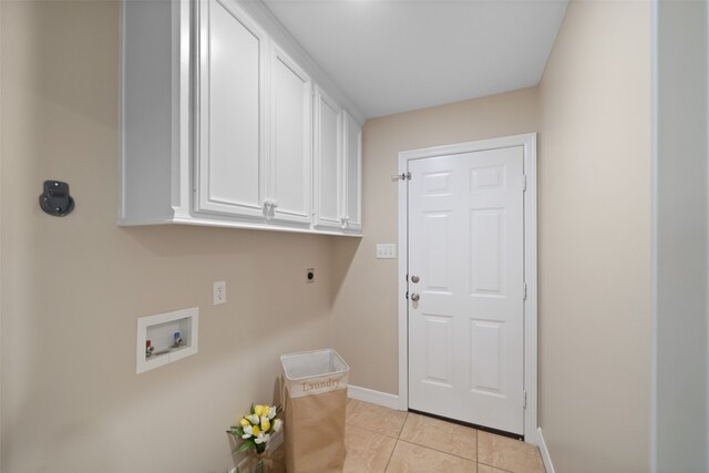 washroom with hookup for an electric dryer, light tile patterned floors, cabinets, and washer hookup