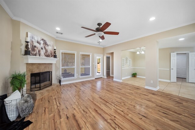 living room with a fireplace, light wood-type flooring, ceiling fan, and ornamental molding