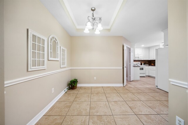 unfurnished dining area featuring a tray ceiling, light tile patterned floors, and a notable chandelier